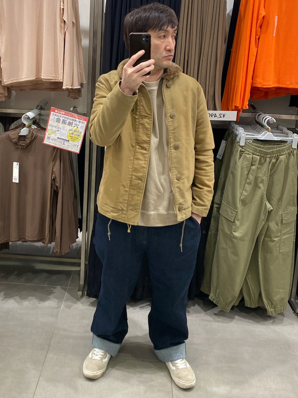 ブラウン系のスウェット、その他のミリタリージャケット、ブルー系のデニムパンツを着用したメンズの冬コーディネートの3枚目の写真