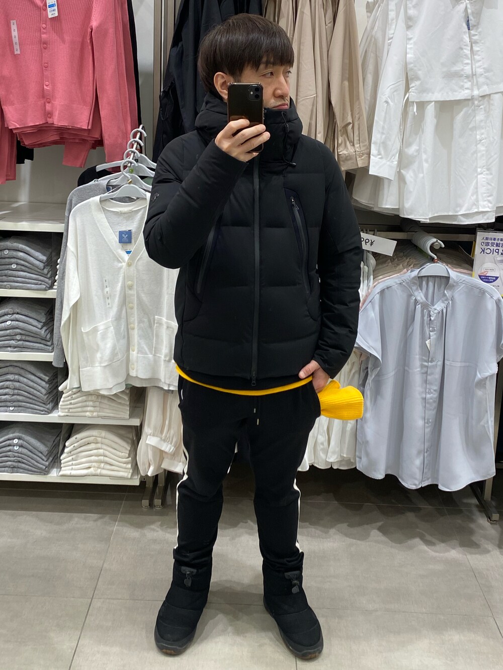 ブラック系のダウンジャケット/コート、ブラック系のスウェット、イエロー系のTシャツ/カットソーを着用したメンズの冬コーディネートの4枚目の写真