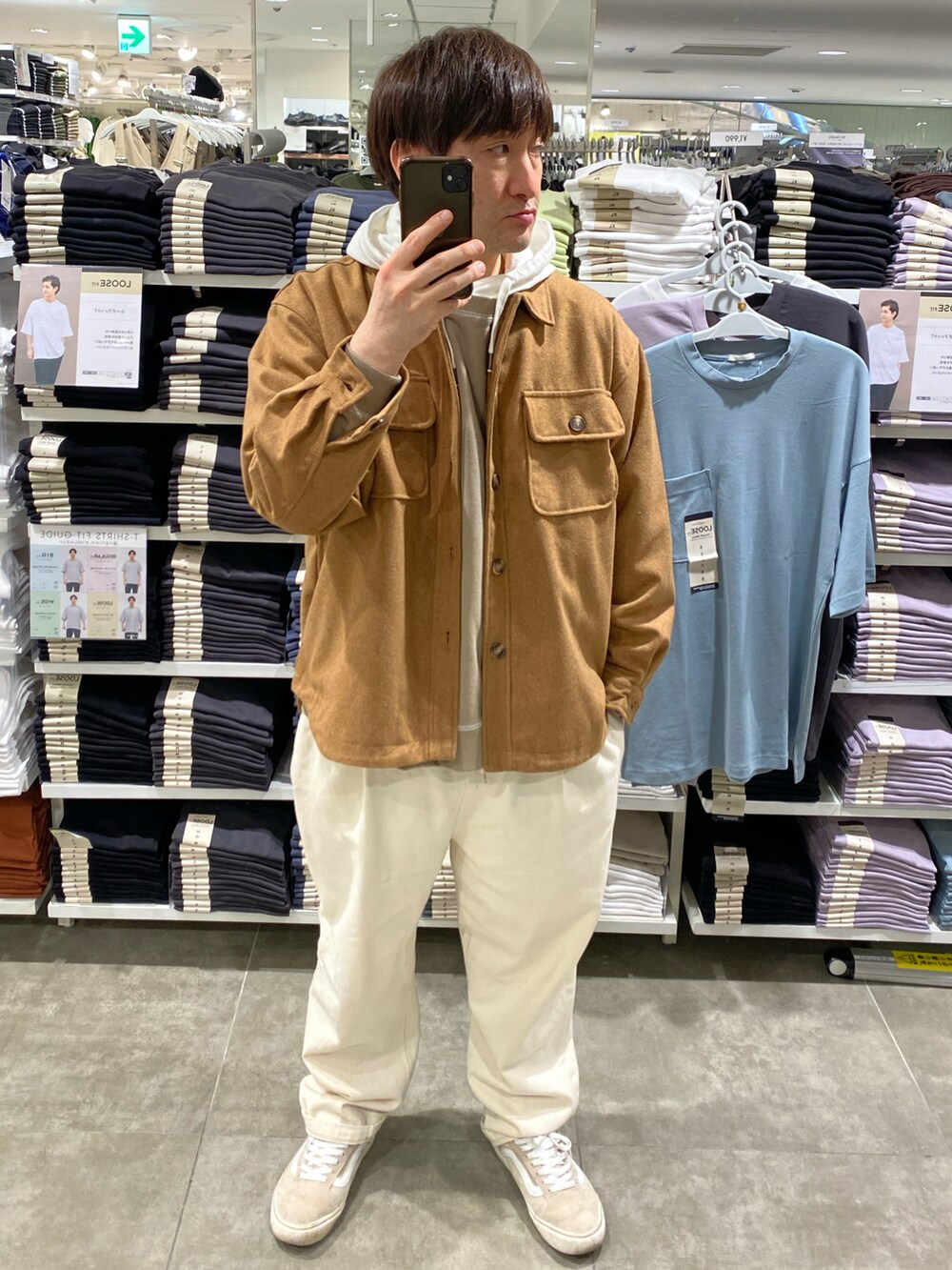 ホワイト系のスラックス、イエロー系のカバーオール、ベージュ系のスニーカーを着用したメンズの春コーディネートの3枚目の写真