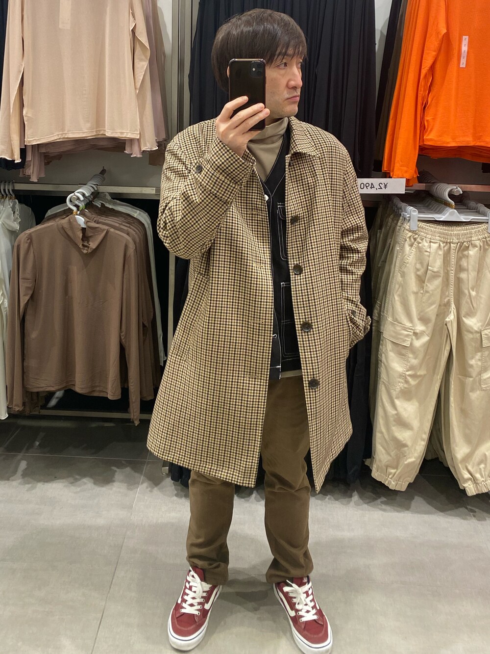 その他のステンカラーコート、ブラウン系のパンツ、レッド系のスニーカーを着用したメンズの冬コーディネートの5枚目の写真