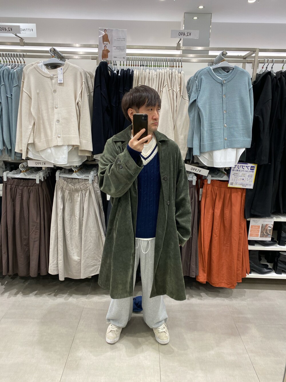 グレー系のスウェットパンツ、ホワイト系のスニーカー、グリーン系のステンカラーコートを着用したメンズの冬コーディネートの3枚目の写真