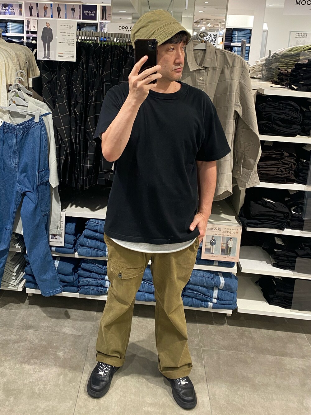 グリーン系のカーゴパンツ、ブラック系のTシャツ/カットソー、ブラック系のスニーカーを着用したメンズの秋コーディネートの2枚目の写真
