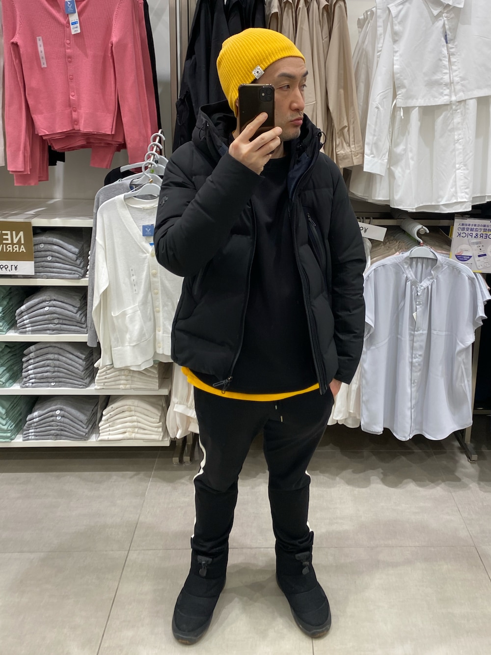 ブラック系のダウンジャケット/コート、ブラック系のスウェット、イエロー系のTシャツ/カットソーを着用したメンズの冬コーディネートの3枚目の写真