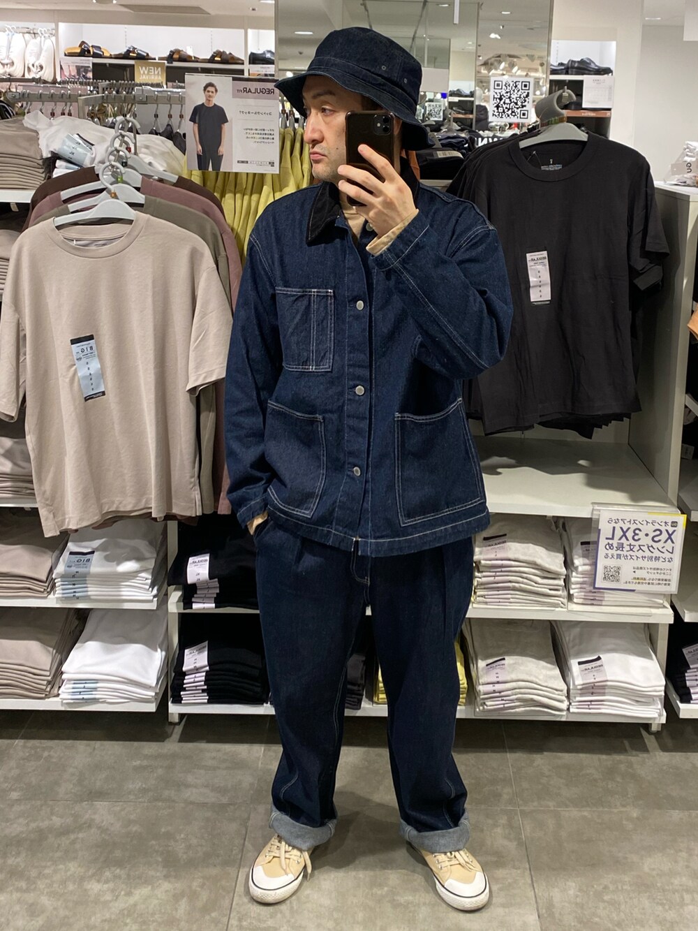ブルー系のカバーオール、ブルー系のデニムパンツ、ベージュ系のスニーカーを着用したメンズの春コーディネートの2枚目の写真