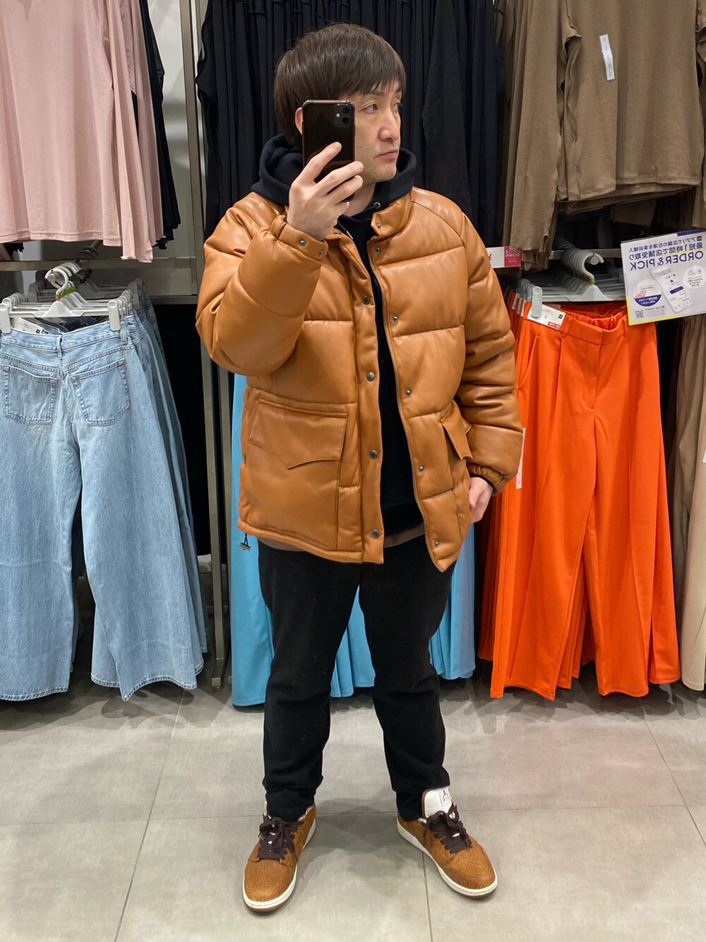 ブラウン系のダウンジャケット/コート、ブラック系のその他パンツ、ブラウン系のスニーカーを着用したメンズの春コーディネートの4枚目の写真