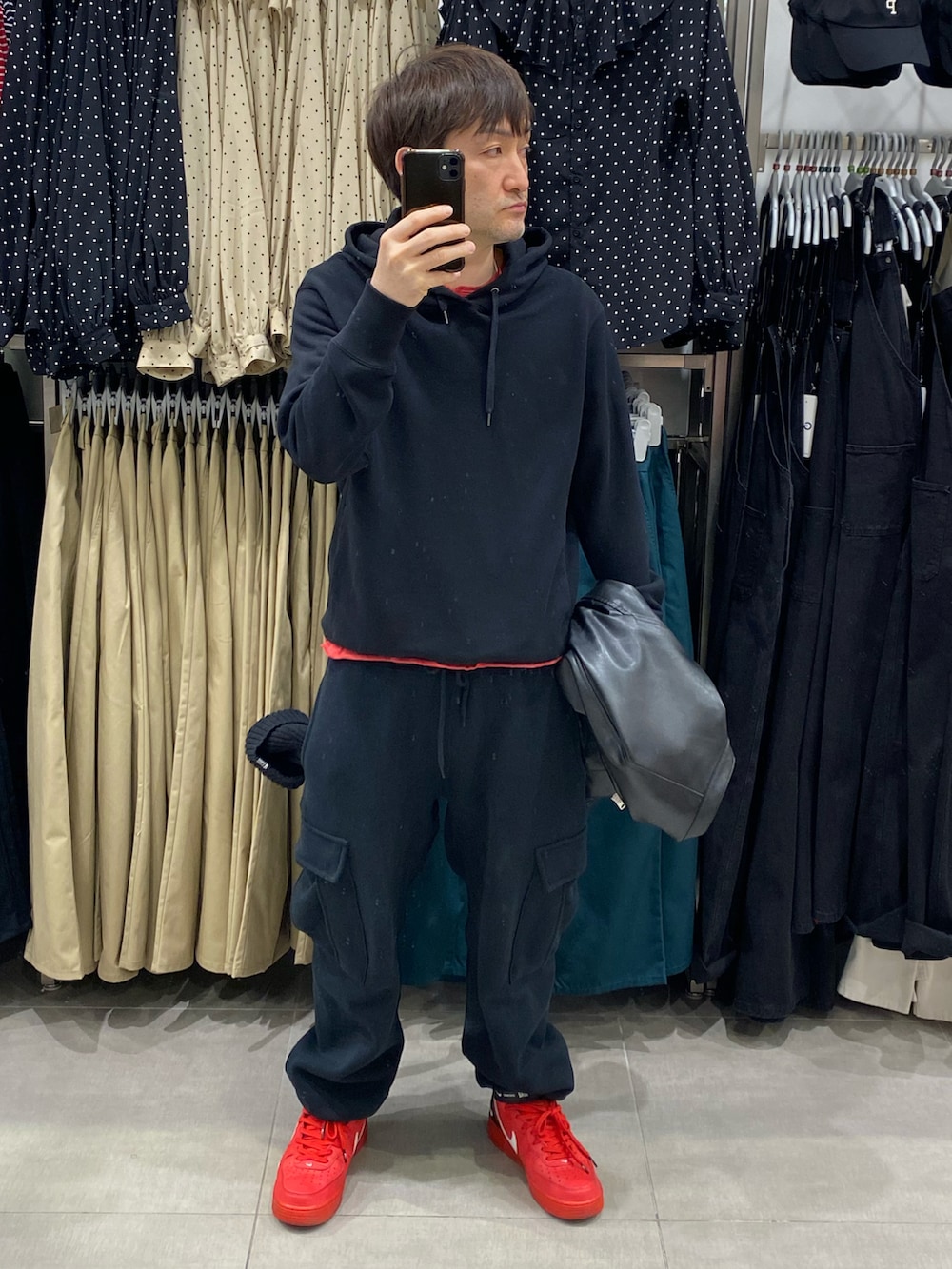 ブラック系のライダースジャケット、ブラック系のパーカー、ブラック系のカーゴパンツを着用したメンズの春コーディネートの2枚目の写真