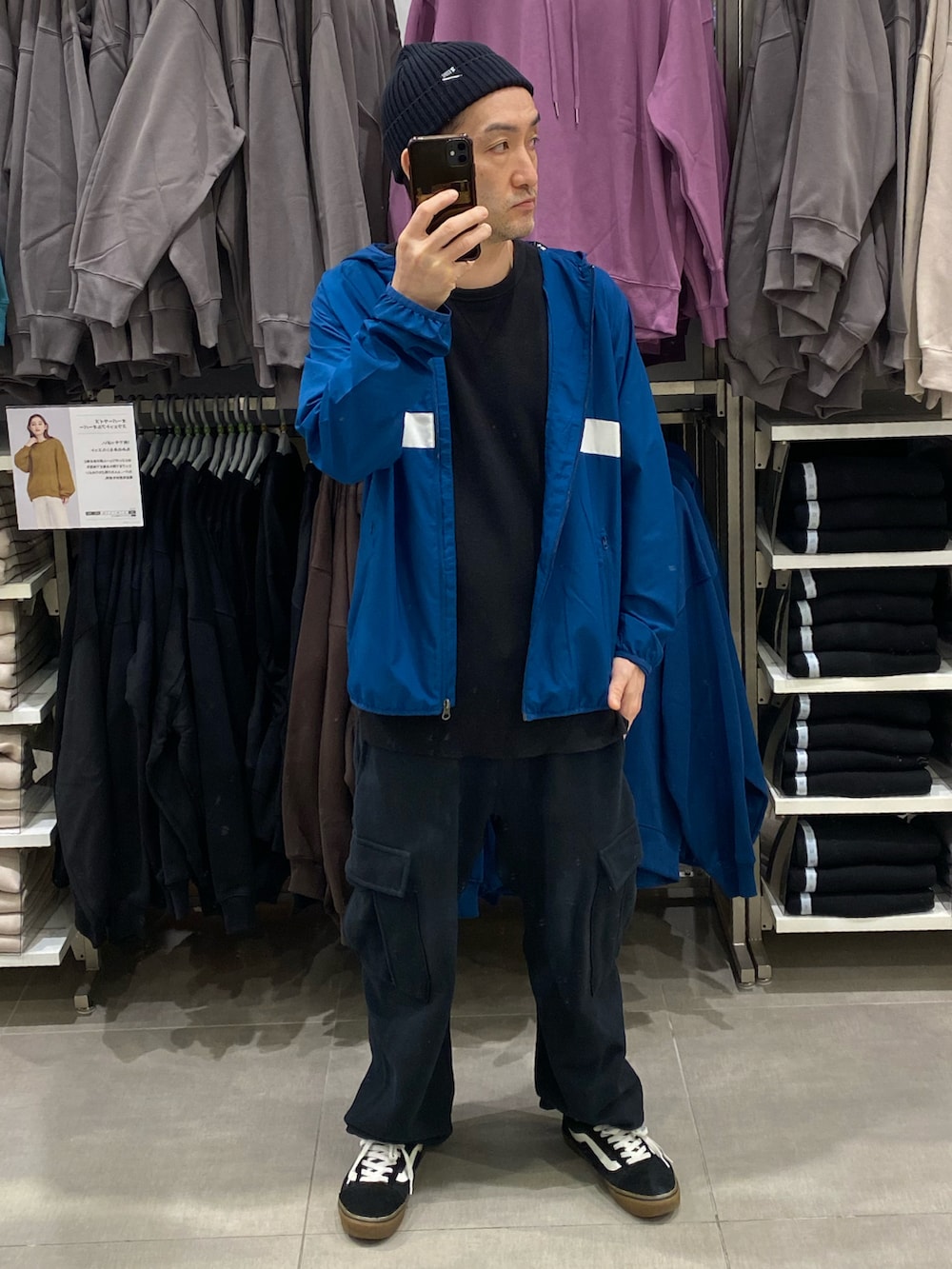ブルー系のナイロンジャケット、ブラック系のカーゴパンツ、ブラック系のスニーカーを着用したメンズの秋コーディネートの3枚目の写真