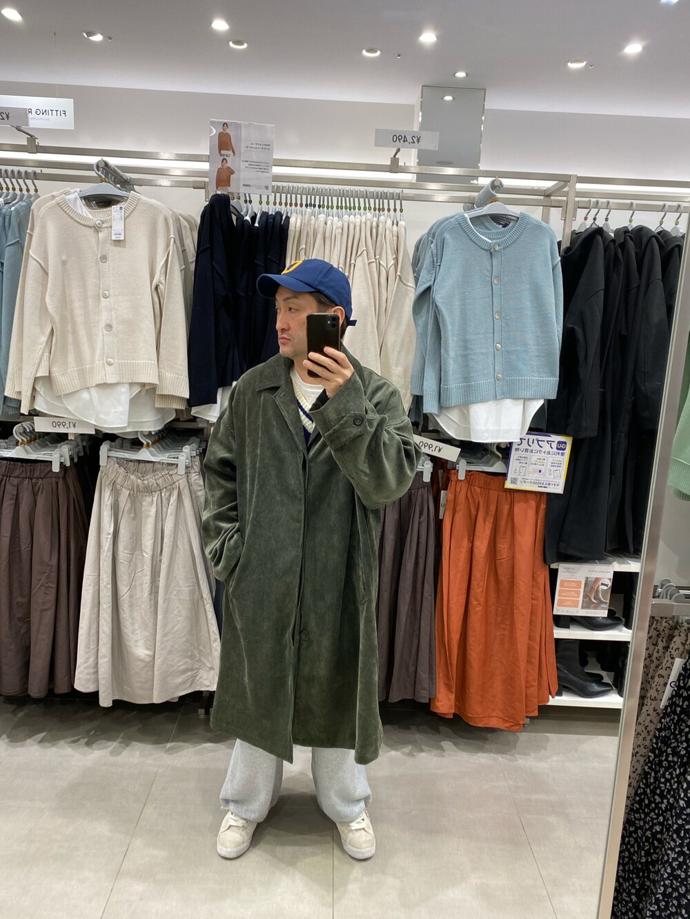 グレー系のスウェットパンツ、ホワイト系のスニーカー、グリーン系のステンカラーコートを着用したメンズの冬コーディネートの4枚目の写真