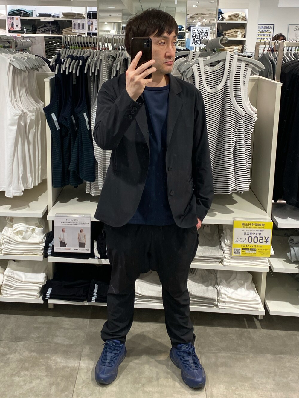 ブラック系のテーラードジャケット、ブラック系のその他パンツ、ブルー系のスニーカーを着用したメンズの春コーディネートの3枚目の写真