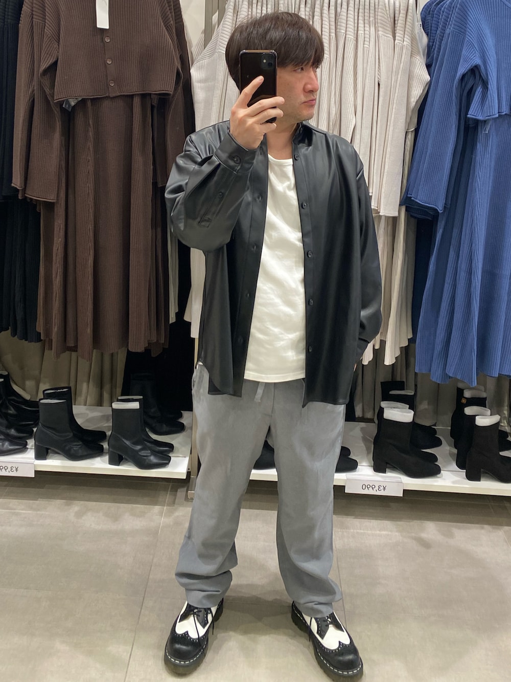 ブラック系のライダースジャケット、グレー系のスラックス、ブラック系のドレスシューズを着用したメンズの秋コーディネートの3枚目の写真