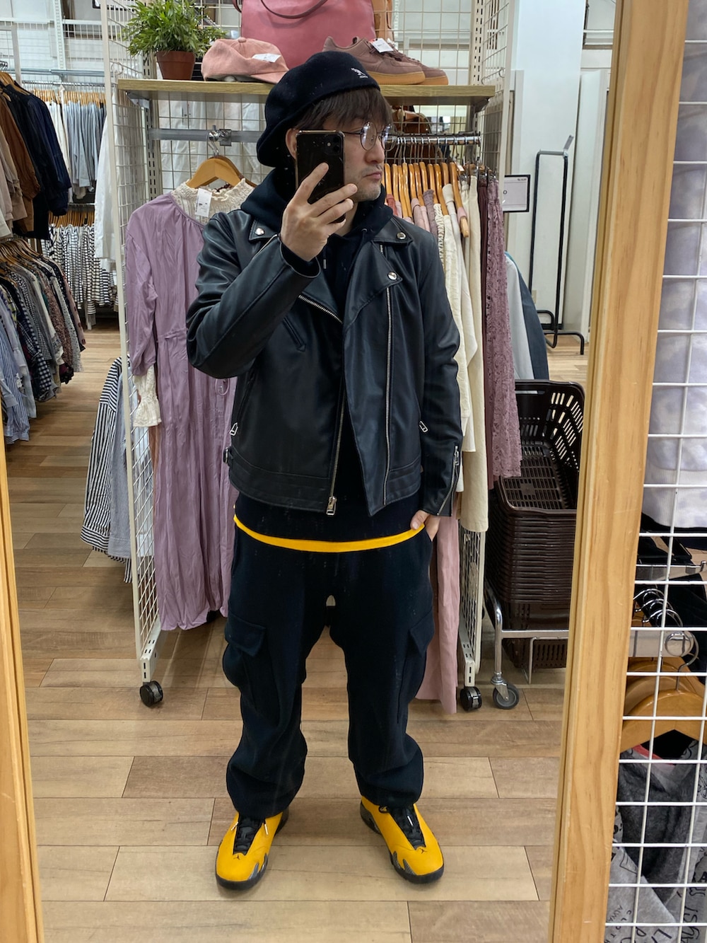 ブラック系のカーゴパンツ、イエロー系のスニーカー、ブラック系のライダースジャケットを着用したメンズの春コーディネートの3枚目の写真