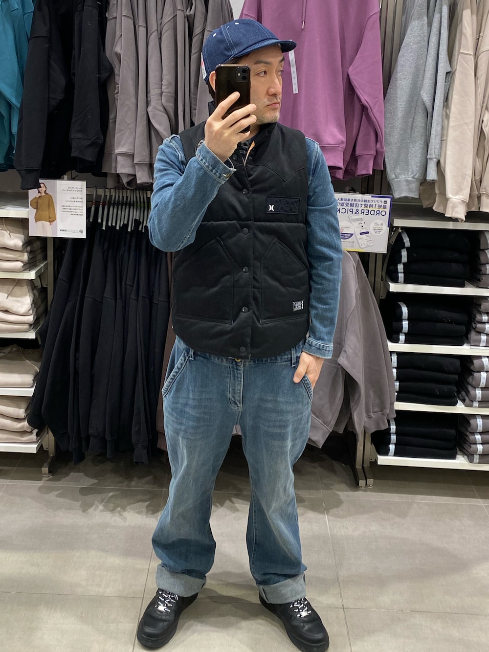 ブルー系のつなぎ/オールインワン、ブラック系のスニーカー、ブラック系のダウンベストを着用したメンズの秋コーディネートの2枚目の写真