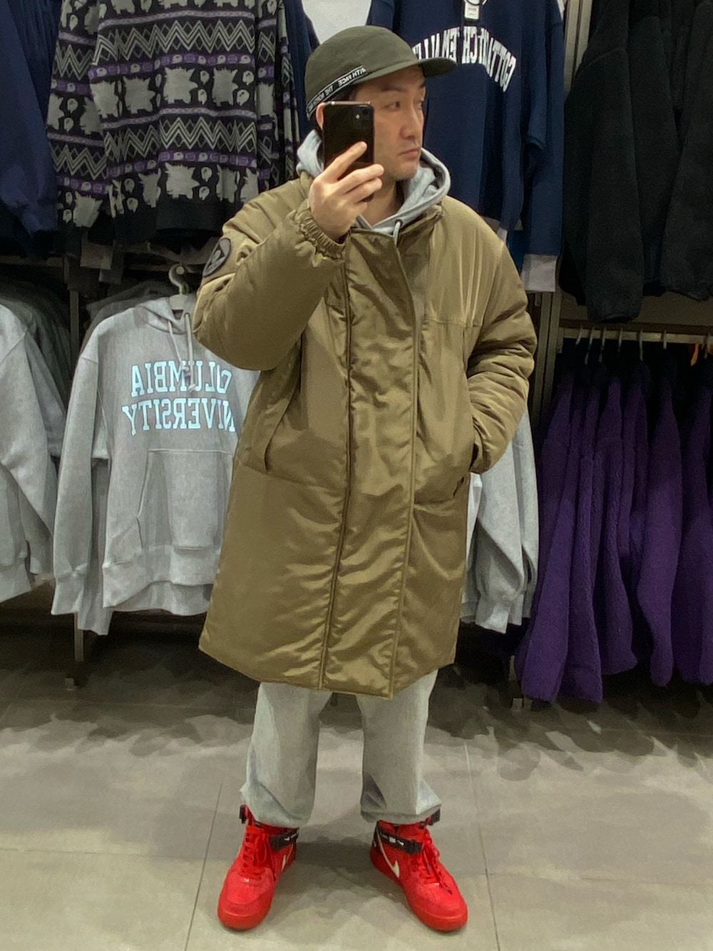 グリーン系のダウンジャケット/コート、グレー系のカーゴパンツ、レッド系のスニーカーを着用したメンズの冬コーディネートの4枚目の写真