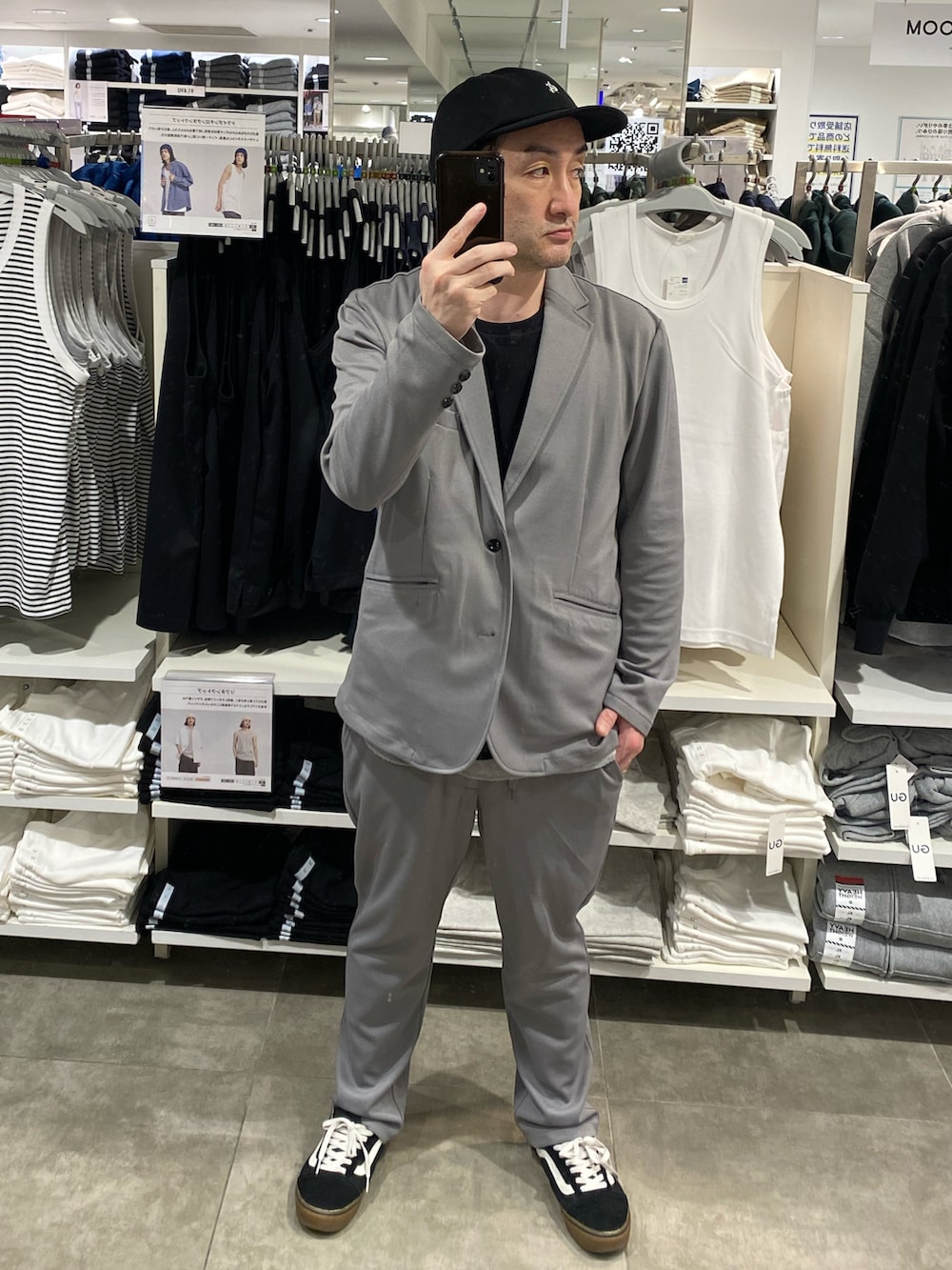 グレー系のセットアップ、ブラック系のTシャツ/カットソー、ブラック系のスニーカーを着用したメンズの春コーディネートの4枚目の写真