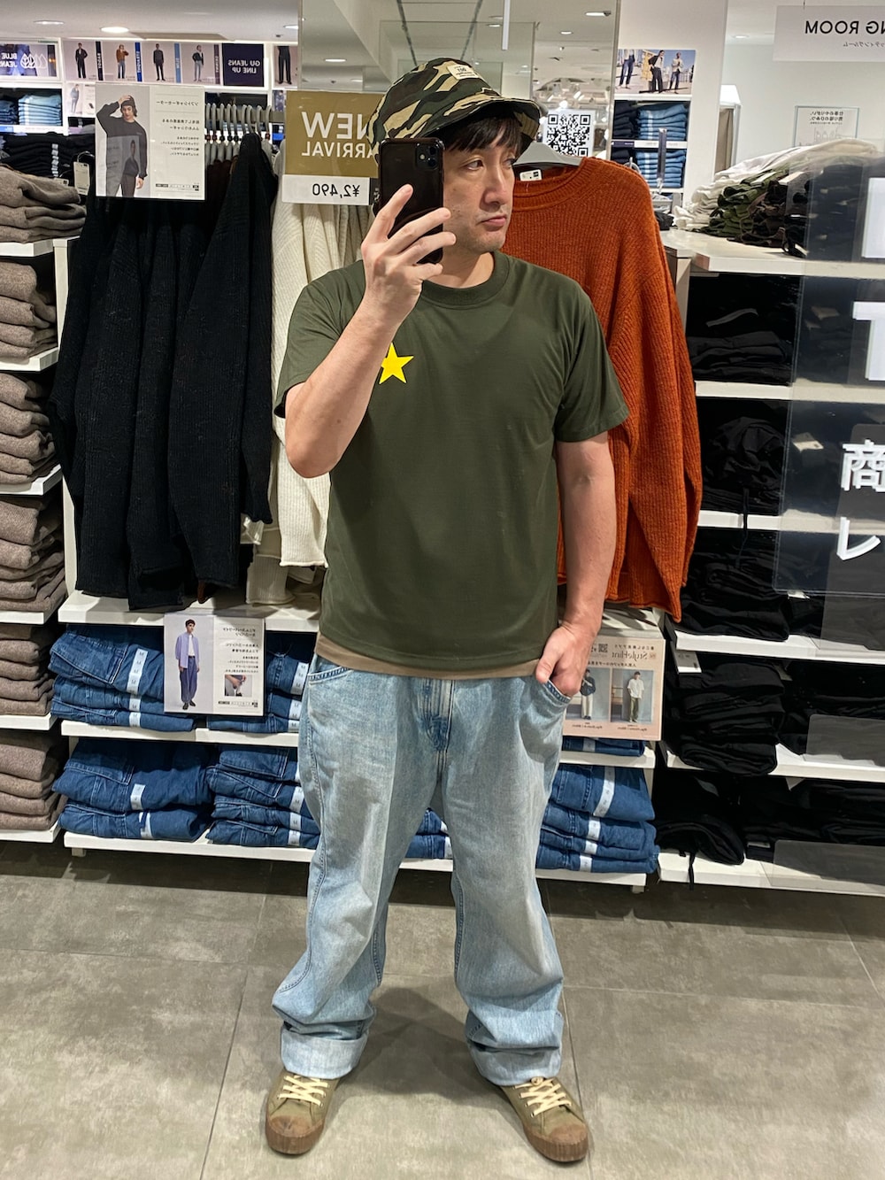 グリーン系のTシャツ/カットソー、ブルー系のデニムパンツ、グリーン系のスニーカーを着用したメンズの秋コーディネートの2枚目の写真