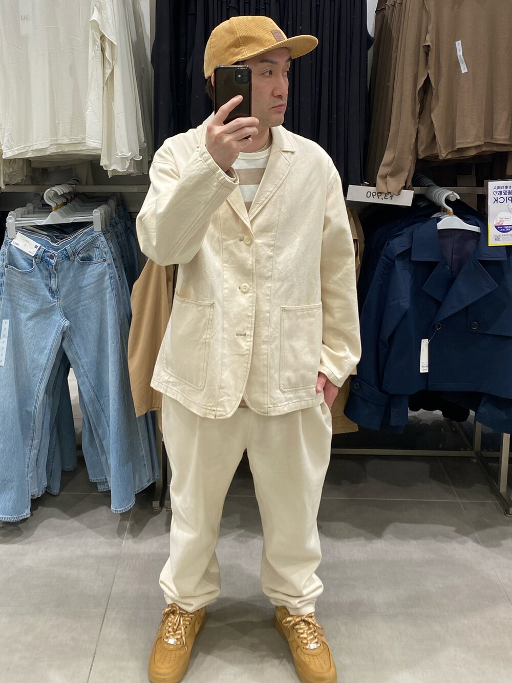 ホワイト系のテーラードジャケット、ホワイト系のスラックス、ブラウン系のスニーカーを着用したメンズの春コーディネートの2枚目の写真