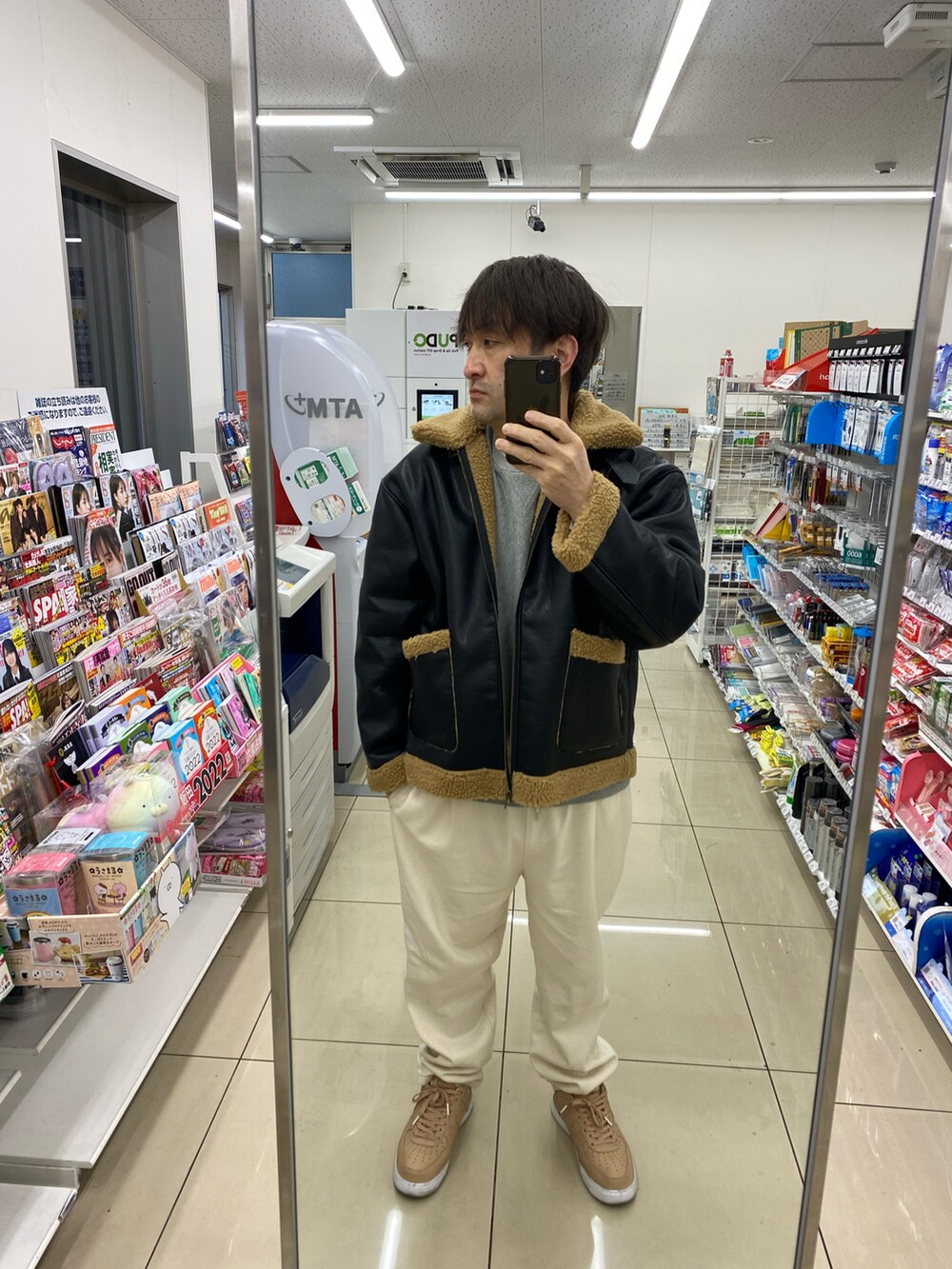 ブラック系のブルゾン、グレー系のスウェット、ホワイト系のスラックスを着用したメンズの冬コーディネートの4枚目の写真