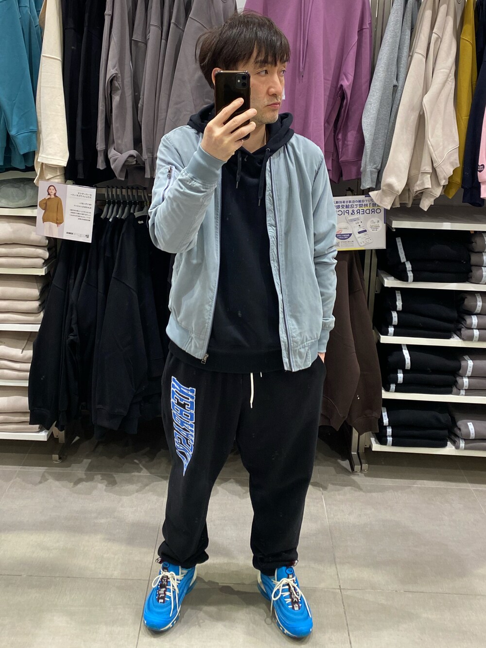 ブラック系のパーカー、ブルー系のMA-1、ブラック系のスウェットパンツを着用したメンズの秋コーディネートの3枚目の写真