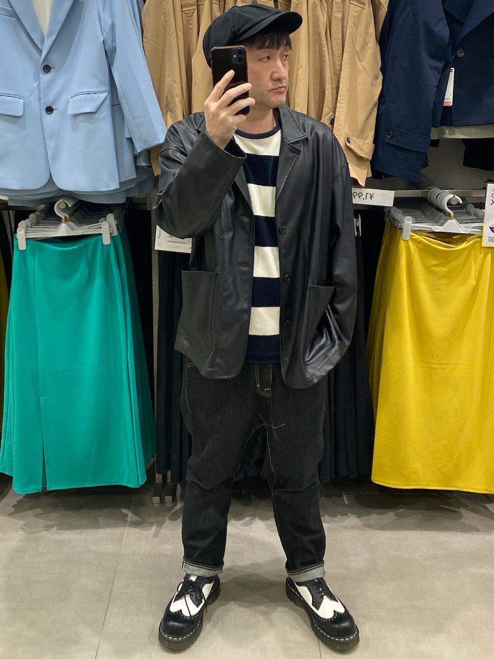 ブラック系のテーラードジャケット、ブルー系のデニムパンツ、ブラック系のドレスシューズを着用したメンズの春コーディネートの2枚目の写真