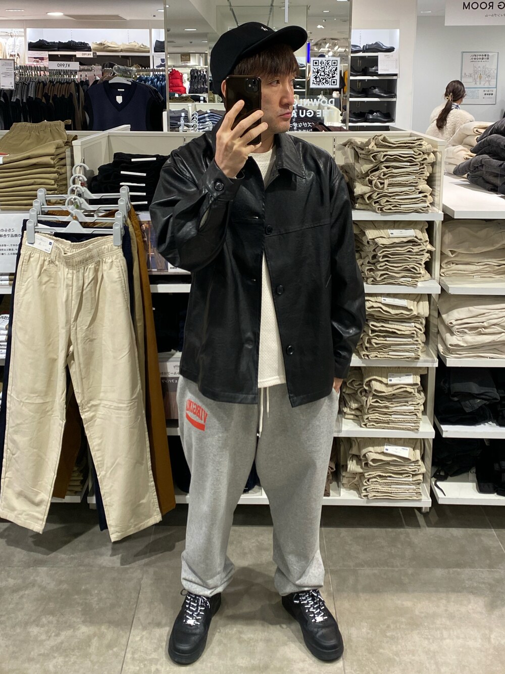 ブラック系のジャケット/アウター、ホワイト系のニット/セーター、グレー系のスウェットパンツを着用したメンズの秋コーディネートの4枚目の写真