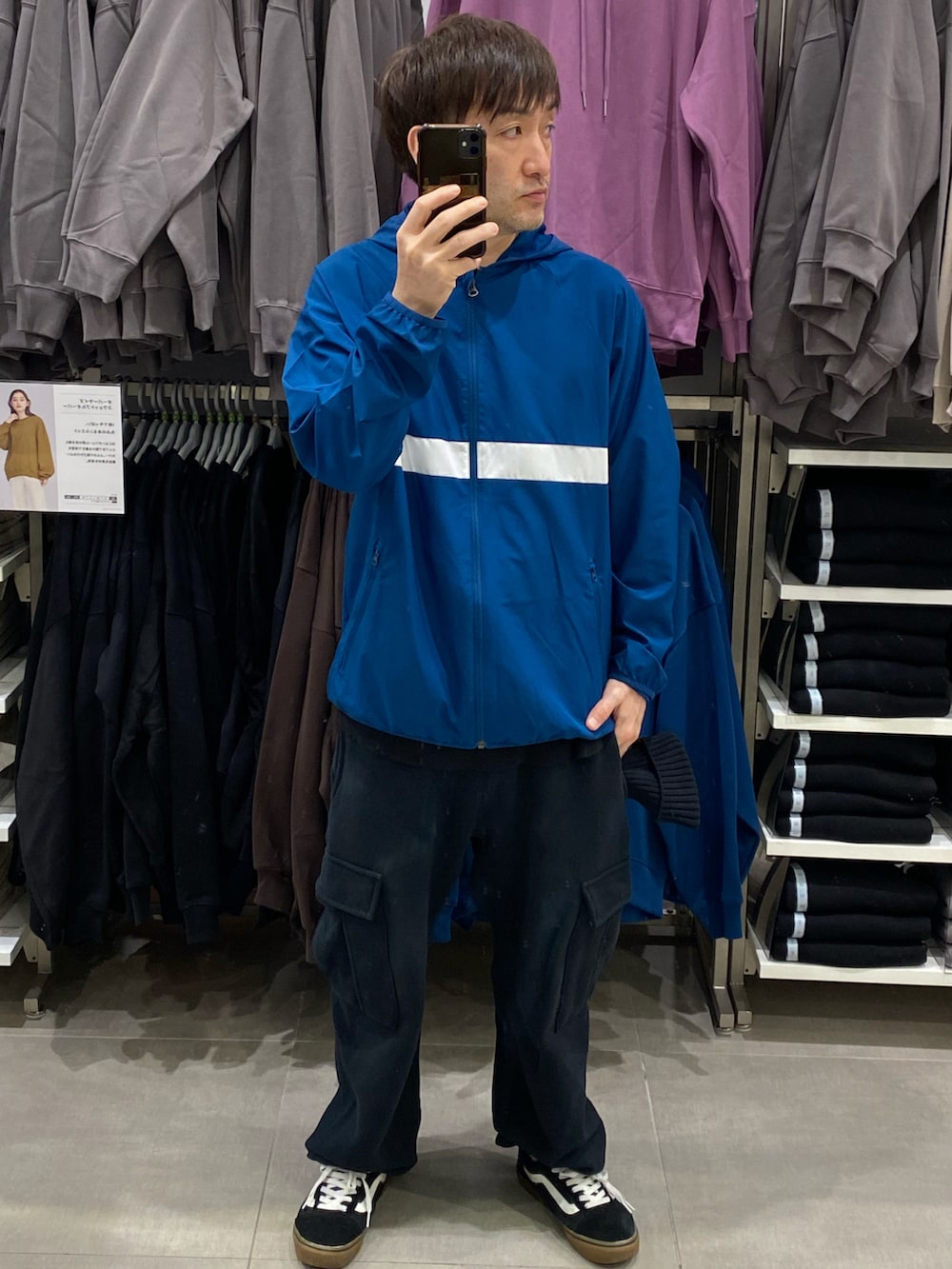 ブルー系のナイロンジャケット、ブラック系のカーゴパンツ、ブラック系のスニーカーを着用したメンズの秋コーディネートの5枚目の写真