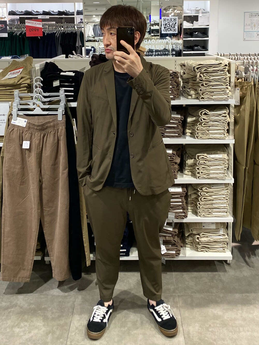 グリーン系のテーラードジャケット、グリーン系のスラックス、ブラック系のスニーカーを着用したメンズの秋コーディネートの4枚目の写真