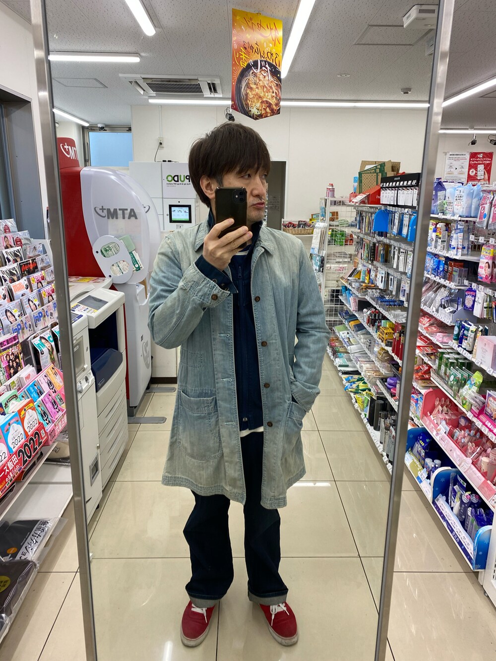 ブルー系のデニムジャケット、ブルー系のステンカラーコート、ブルー系のデニムパンツを着用したメンズの秋コーディネートの3枚目の写真