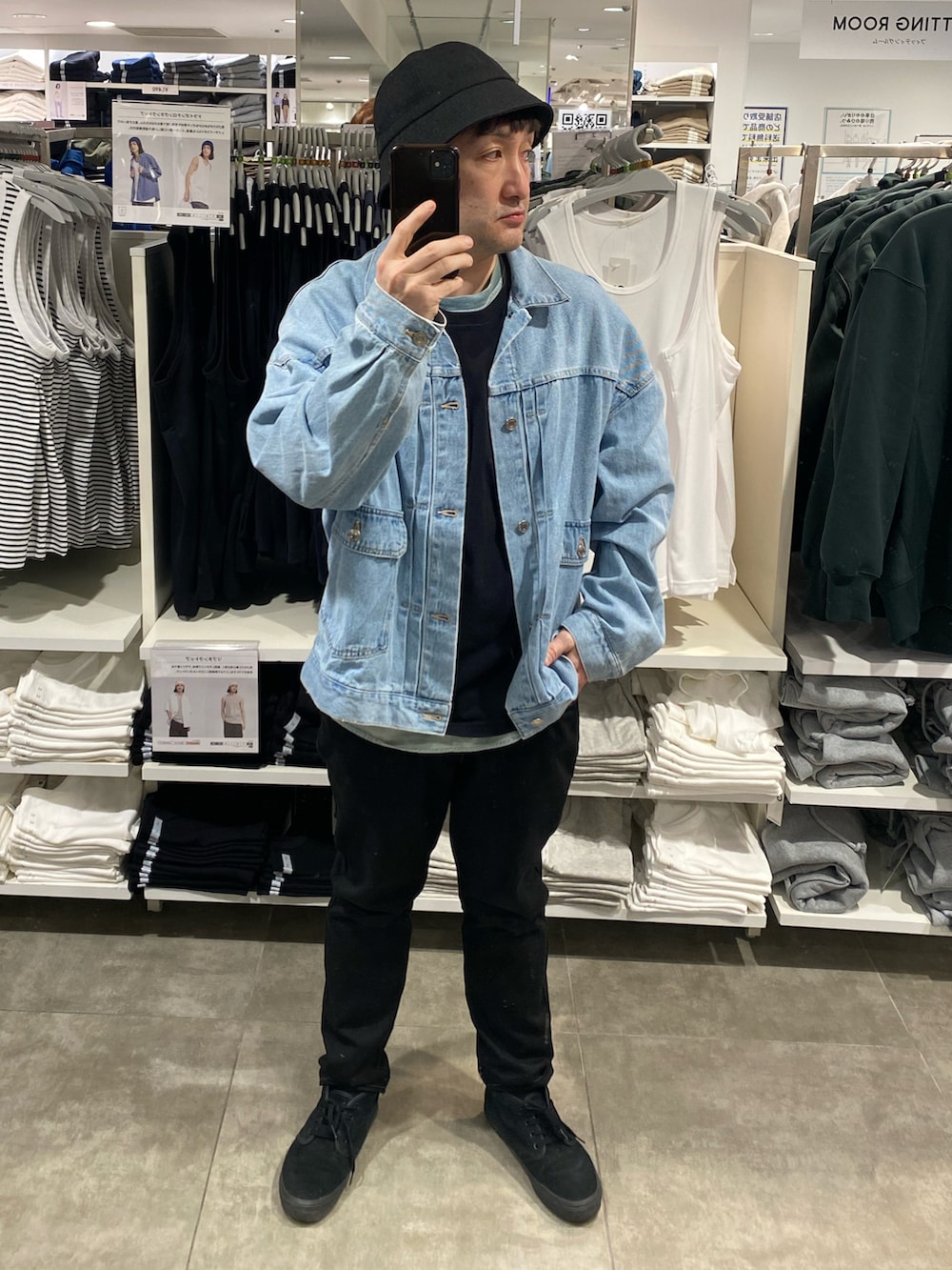 ブルー系のデニムジャケット、ブラック系のパンツ、ブラック系のスニーカーを着用したメンズの春コーディネートの4枚目の写真