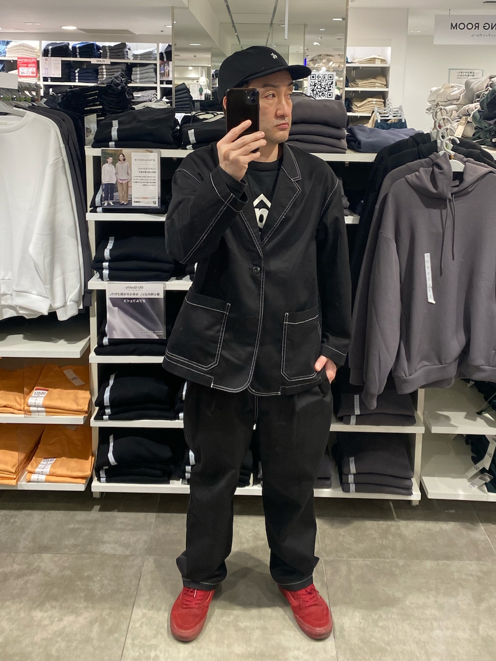 ブラック系のテーラードジャケット、ブラック系のその他パンツ、レッド系のスニーカーを着用したメンズの春コーディネートの4枚目の写真