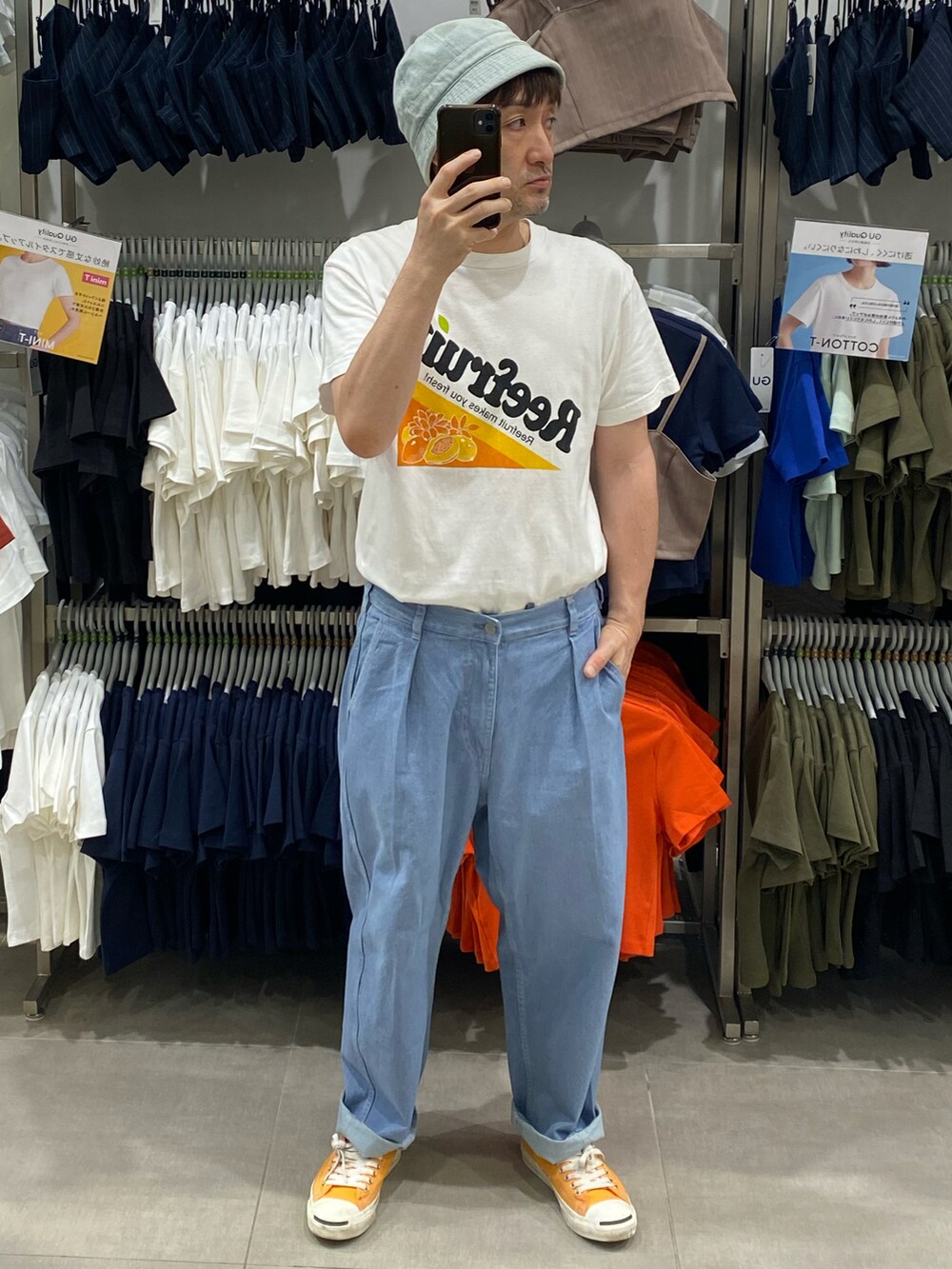 ブルー系のデニムパンツ、ホワイト系のTシャツ/カットソー、オレンジ系のスニーカーを着用したメンズの秋コーディネートの2枚目の写真