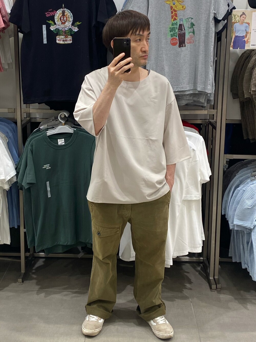 ホワイト系のTシャツ/カットソー、グリーン系のカーゴパンツ、ベージュ系のスニーカーを着用したメンズの夏コーディネートの3枚目の写真