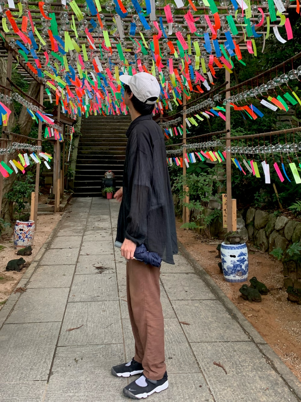 ブラック系のシャツ/ブラウス、ブラウン系のパンツ、ブラック系のスニーカーを着用したメンズの夏コーディネートの2枚目の写真