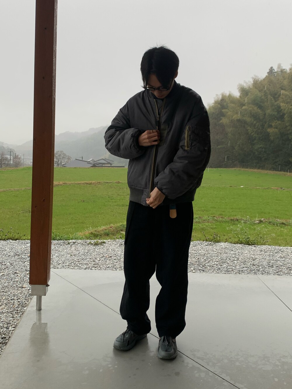 グリーン系のジャケット/アウター、ブラック系のスニーカーを着用したメンズの春コーディネートの2枚目の写真