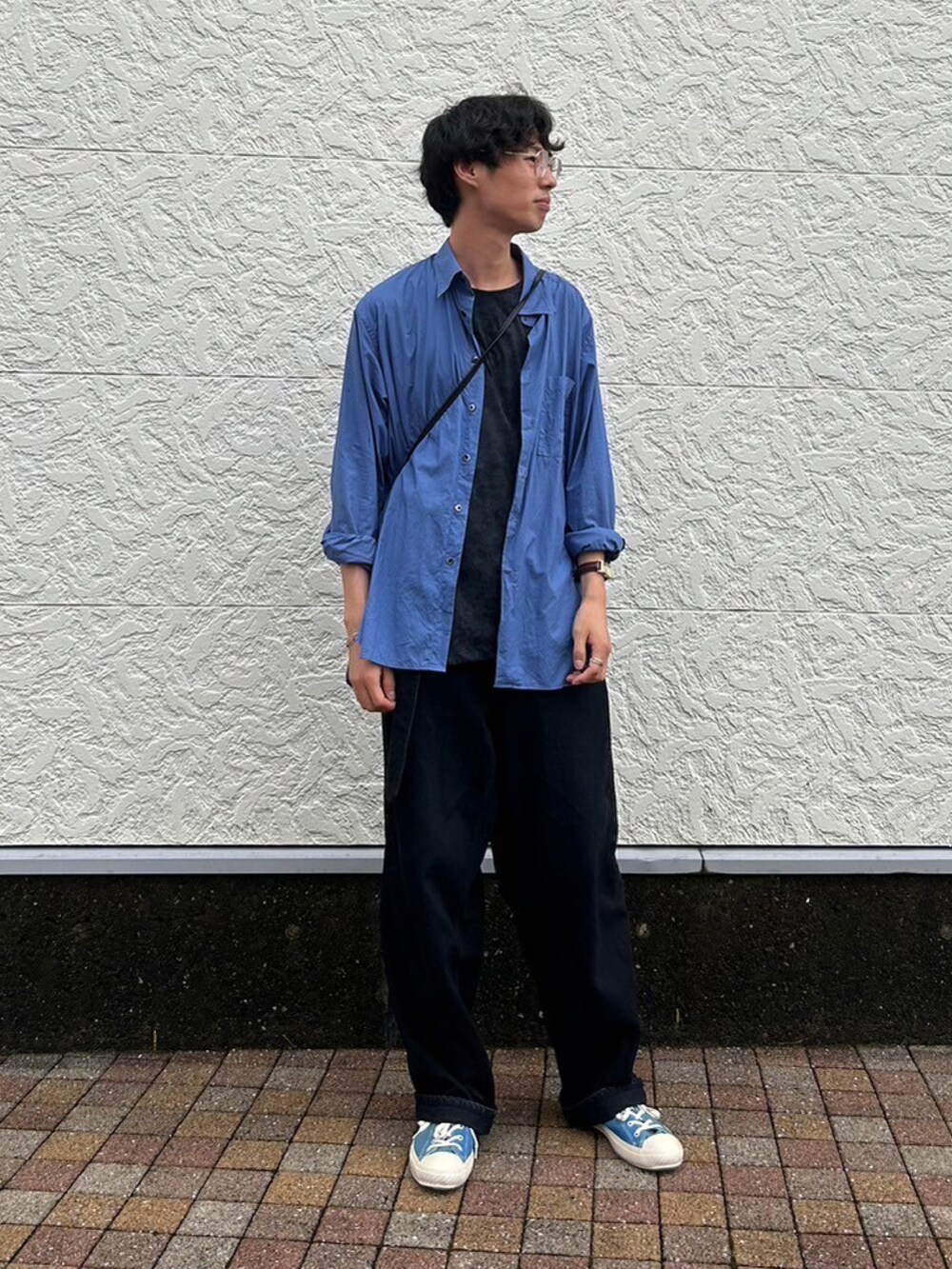 ブラック系のデニムパンツ、ブルー系のスニーカー、ブラック系のTシャツ/カットソーを着用したメンズの春コーディネートの2枚目の写真