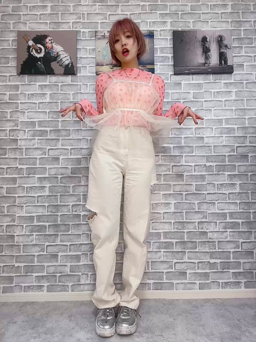 ピンク系のTシャツ/カットソー、ベージュ系のデニムパンツ、ホワイト系のキャミソールを着用したレディースの春コーディネートの4枚目の写真