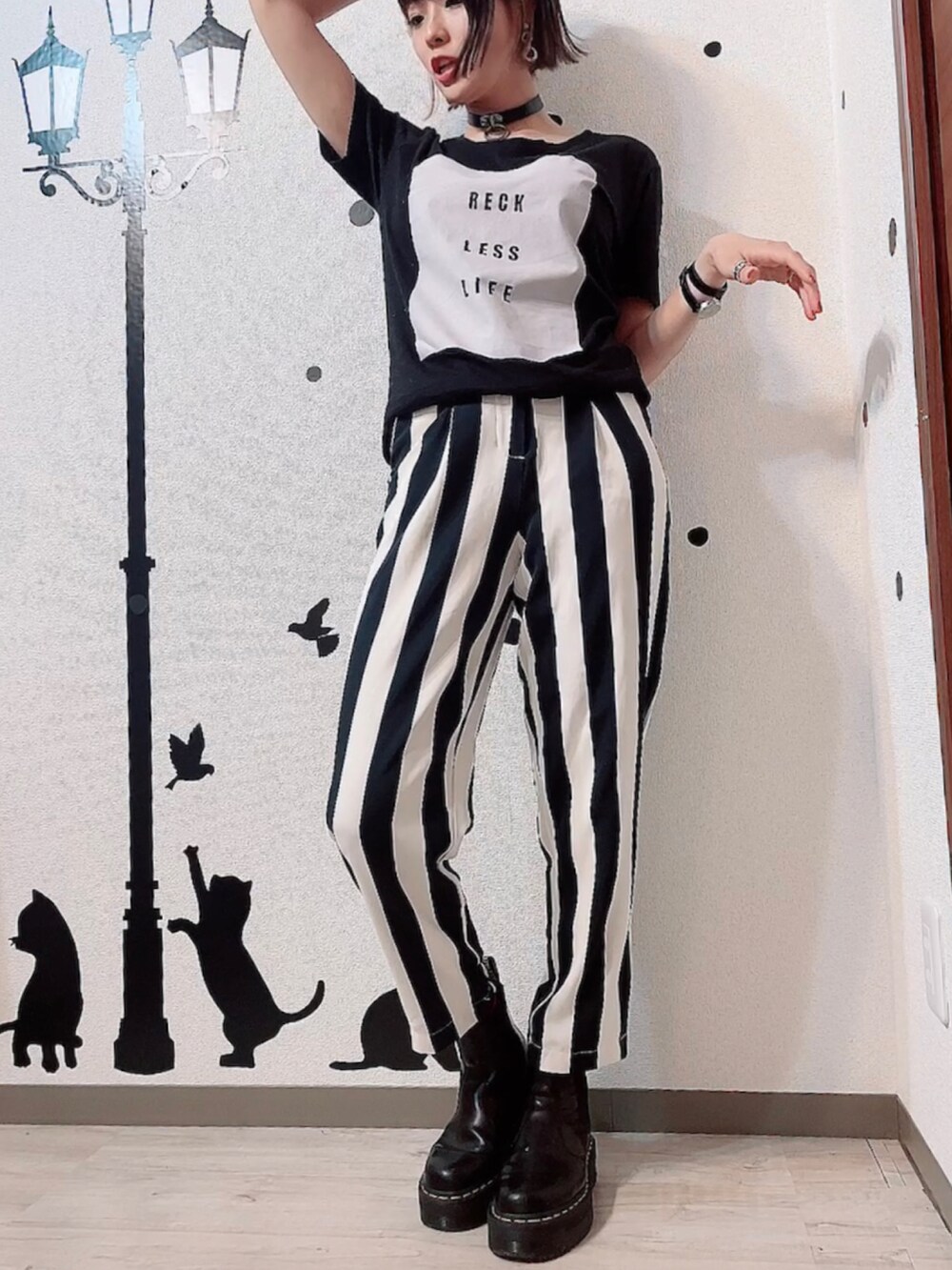 ブラック系のパンツ、ブラック系のブーツ、ホワイト系のデニムジャケットを着用したレディースの春コーディネートの2枚目の写真
