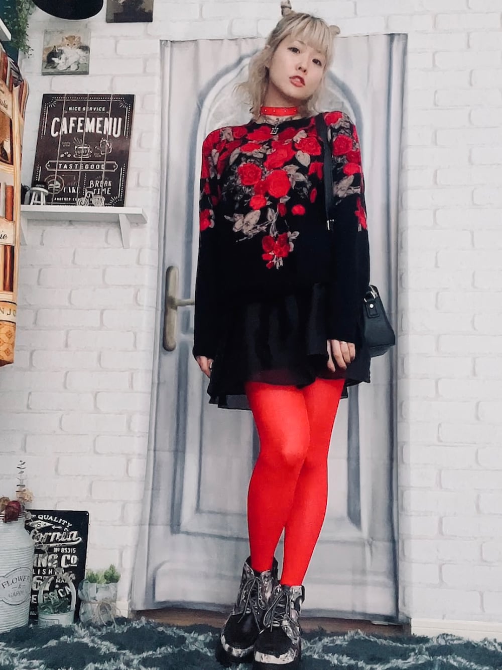 レッド系のニット/セーター、ブラック系のスカート、ブラック系のスニーカーを着用したレディースの秋コーディネートの2枚目の写真