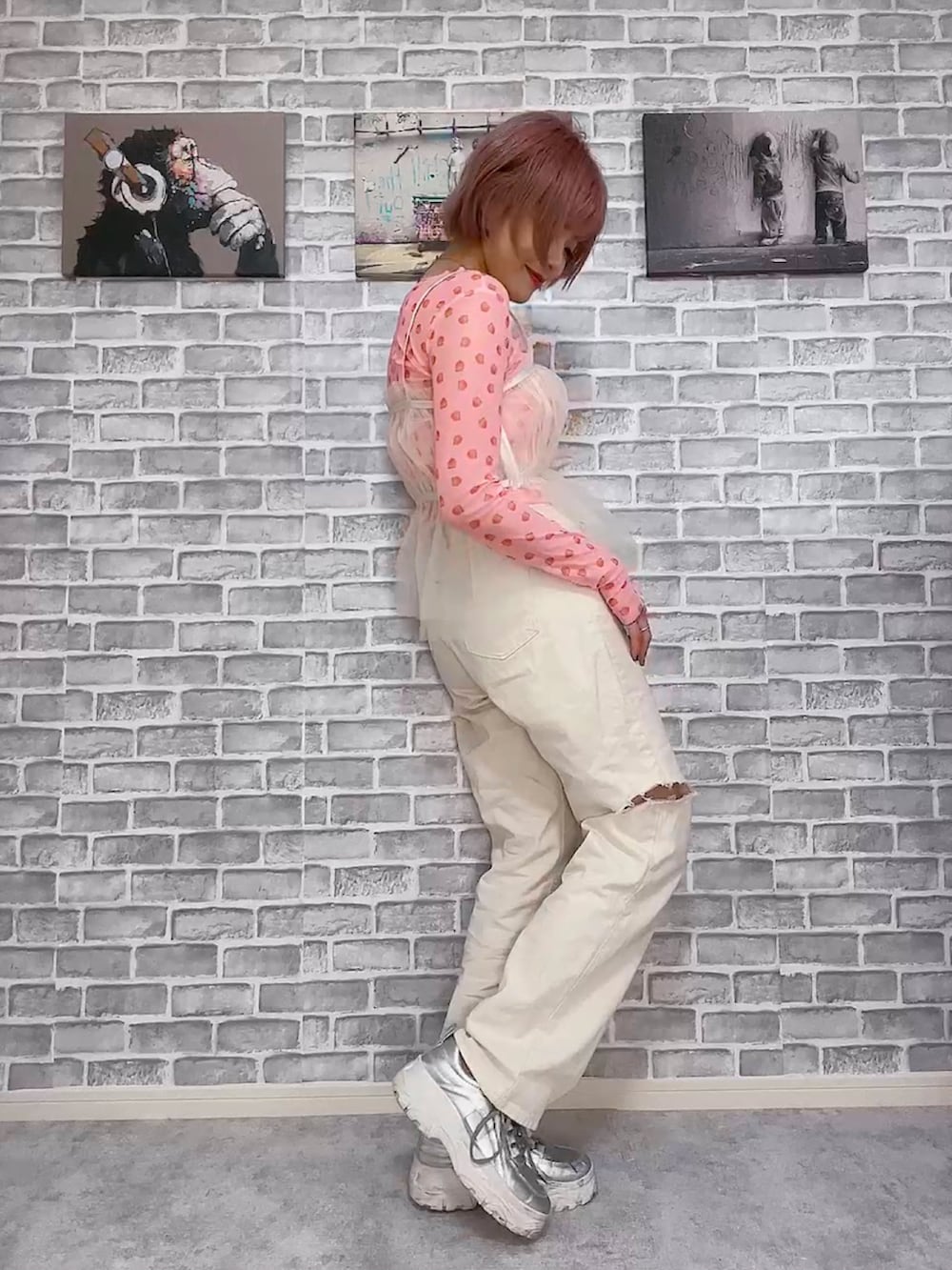 ピンク系のTシャツ/カットソー、ベージュ系のデニムパンツ、ホワイト系のキャミソールを着用したレディースの春コーディネートの3枚目の写真