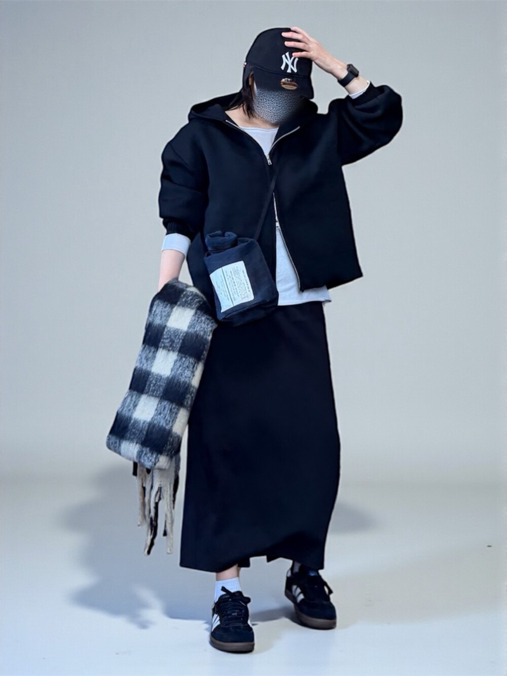 ブラック系のカーディガン/ボレロ、ブラック系のショルダーバッグ、ブラック系のスニーカーを着用したレディースの冬コーディネートの3枚目の写真