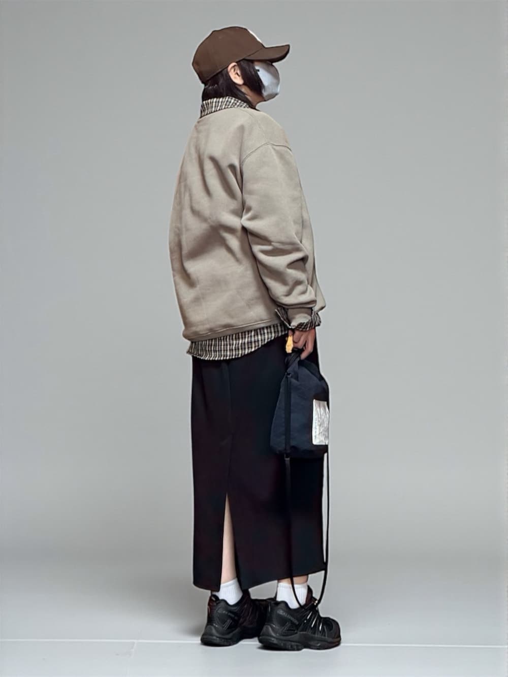 ベージュ系のスウェット、ブラック系のスニーカー、ブラック系のショルダーバッグを着用したレディースの冬コーディネートの3枚目の写真