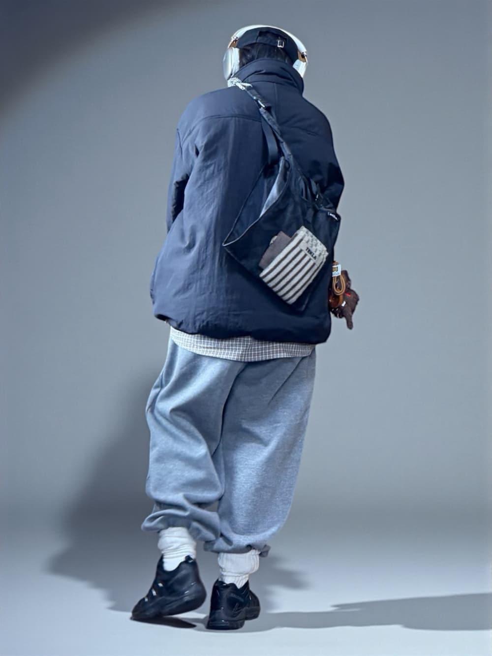 ブラック系のダウンジャケット/コート、グレー系のスウェットパンツ、ベージュ系のシャツ/ブラウスを着用したレディースの冬コーディネートの4枚目の写真