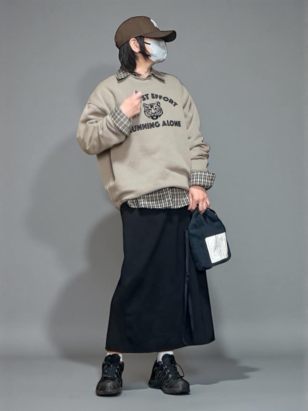 ベージュ系のスウェット、ブラック系のスニーカー、ブラック系のショルダーバッグを着用したレディースの冬コーディネートの2枚目の写真