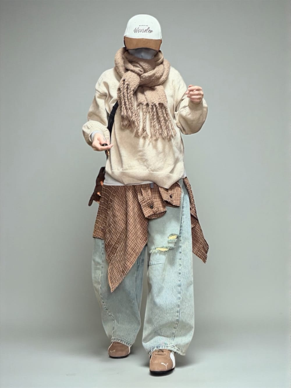 ブルー系のデニムパンツ、ブラック系のエコバッグ/サブバッグ、ブラウン系のスニーカーを着用したレディースの冬コーディネートの2枚目の写真