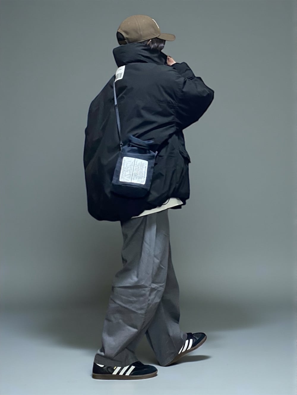 ブラック系のダウンジャケット/コート、ブラック系のショルダーバッグ、グレー系のチノパンツを着用したレディースの秋コーディネートの2枚目の写真