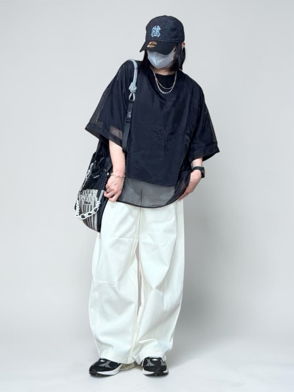 ブラック系のTシャツ/カットソー、ブラック系のエコバッグ/サブバッグ、ホワイト系のその他パンツを着用したレディースの春コーディネートの2枚目の写真
