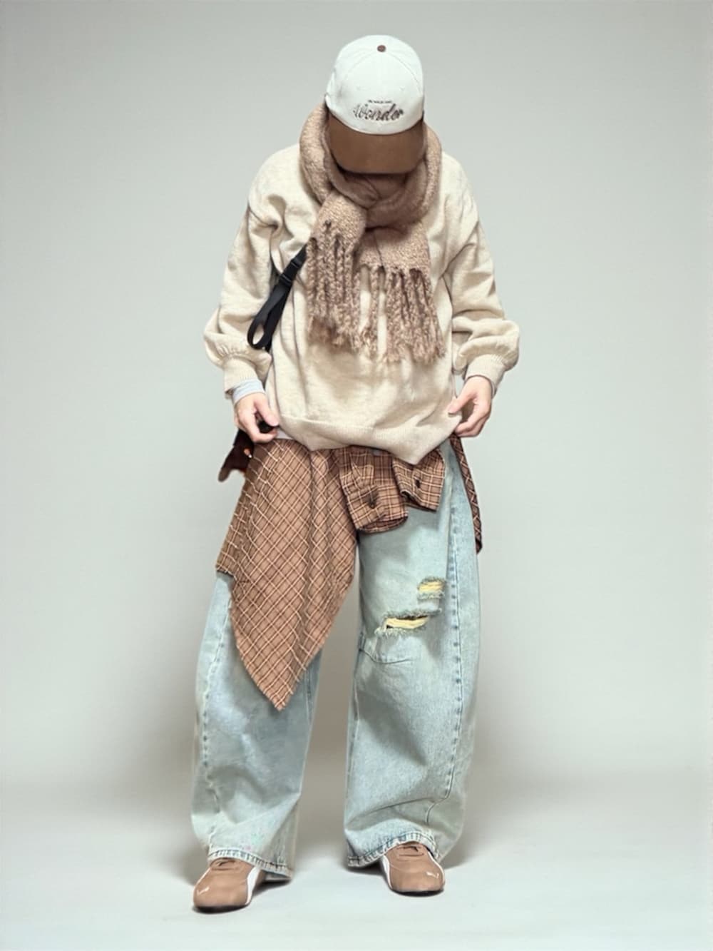 ブルー系のデニムパンツ、ブラック系のエコバッグ/サブバッグ、ブラウン系のスニーカーを着用したレディースの冬コーディネートの3枚目の写真