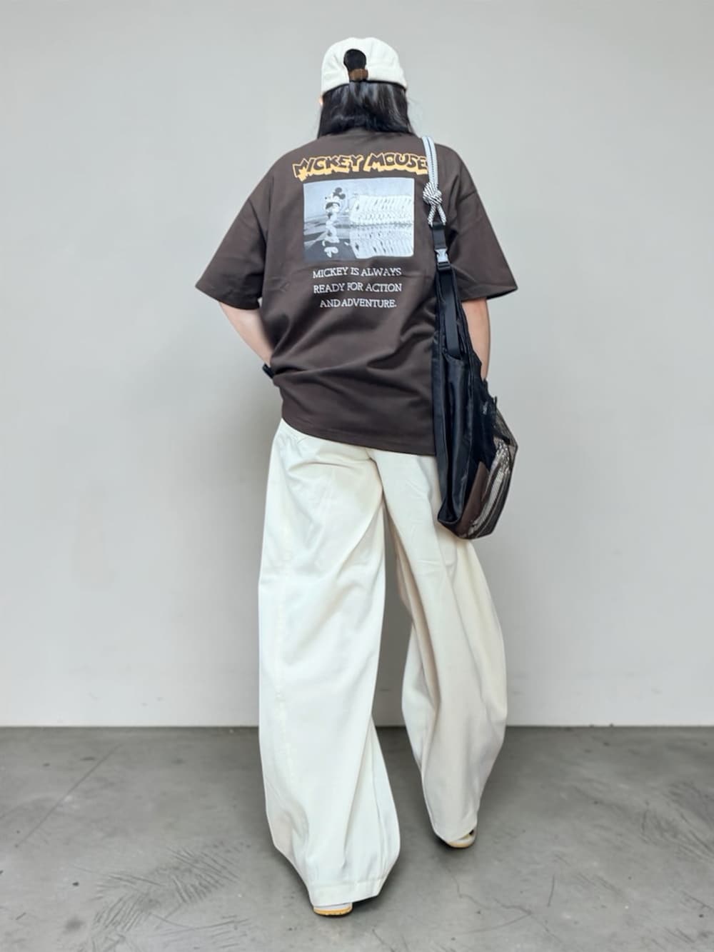 ブラウン系のTシャツ/カットソー、ホワイト系のその他パンツ、ブラック系のエコバッグ/サブバッグを着用したレディースの夏コーディネートの2枚目の写真