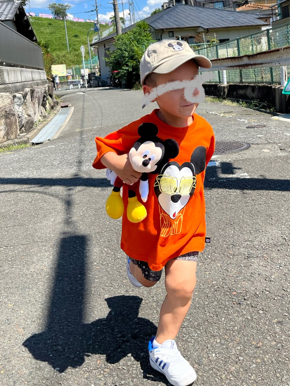 オレンジ系のTシャツ/カットソー、ブラック系のパンツ、ホワイト系のスニーカーを着用したキッズの秋コーディネートの2枚目の写真