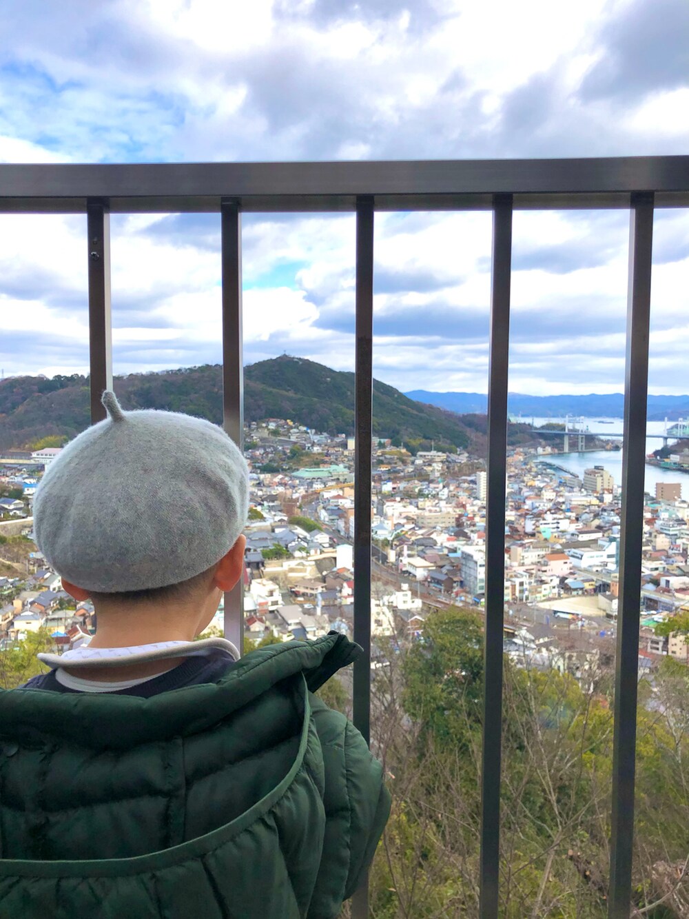 グリーン系のダウンジャケット/コート、ブラック系のスウェット、ベージュ系のデニムパンツを着用したキッズの冬コーディネートの2枚目の写真