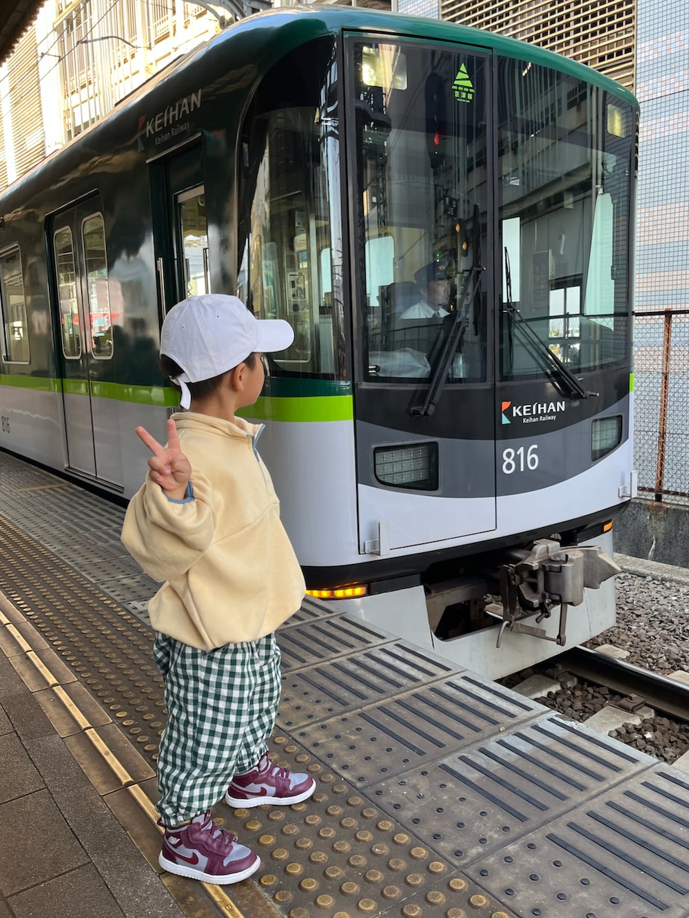 ホワイト系のダウンベスト、ベージュ系のテーラードジャケット、ブラック系のデニムパンツを着用したレディースの秋コーディネートの2枚目の写真